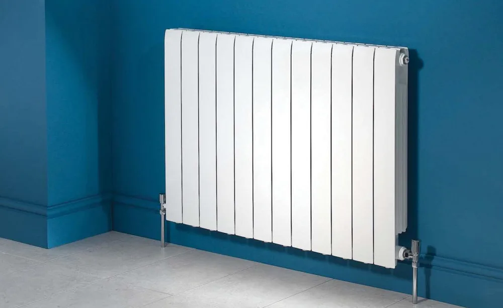 White panel radiator against a blue wall